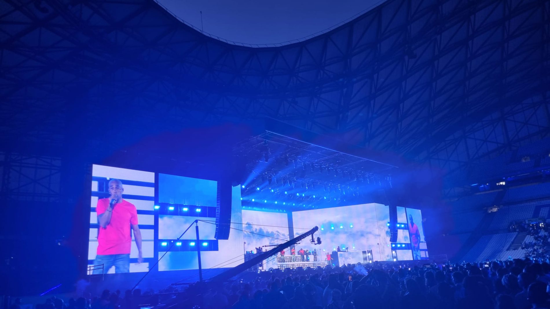 Stadium concert sound: LED video walls, rigging truss and blue lighting