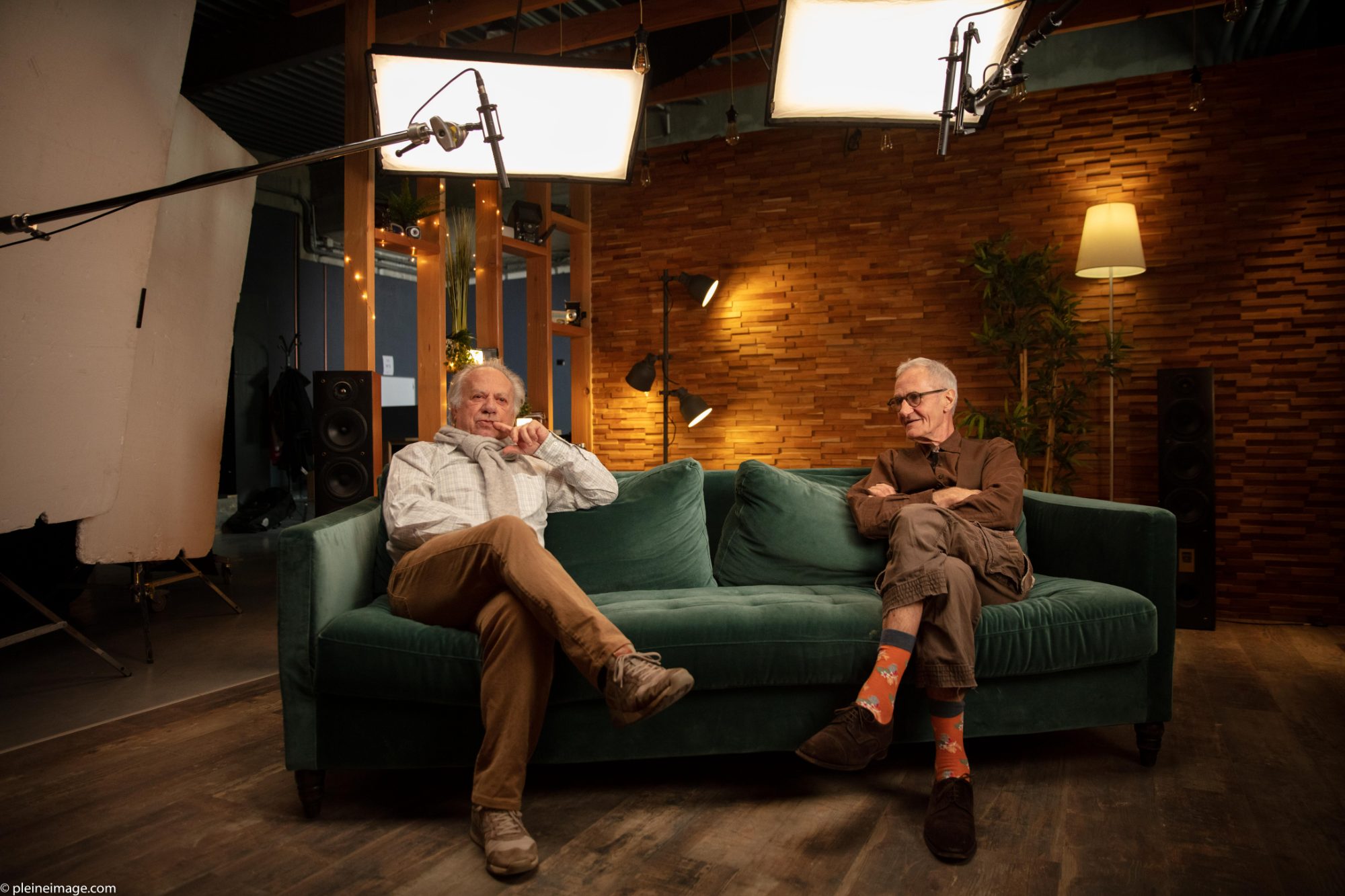 Interview de deux intervenants sur un canapé, sous deux panneaux de lumière